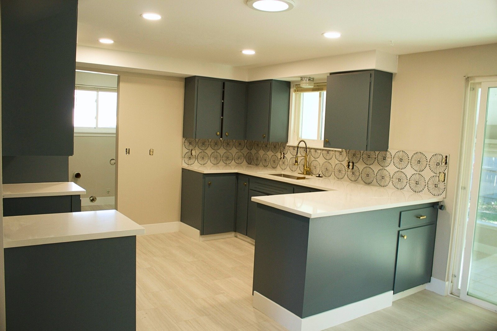 Kitchen with dark green painted cabinets and light walls