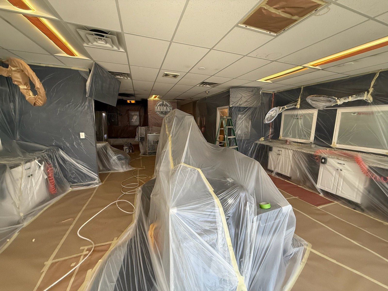 Commercial space with floors and fixtures fully masked before painting
